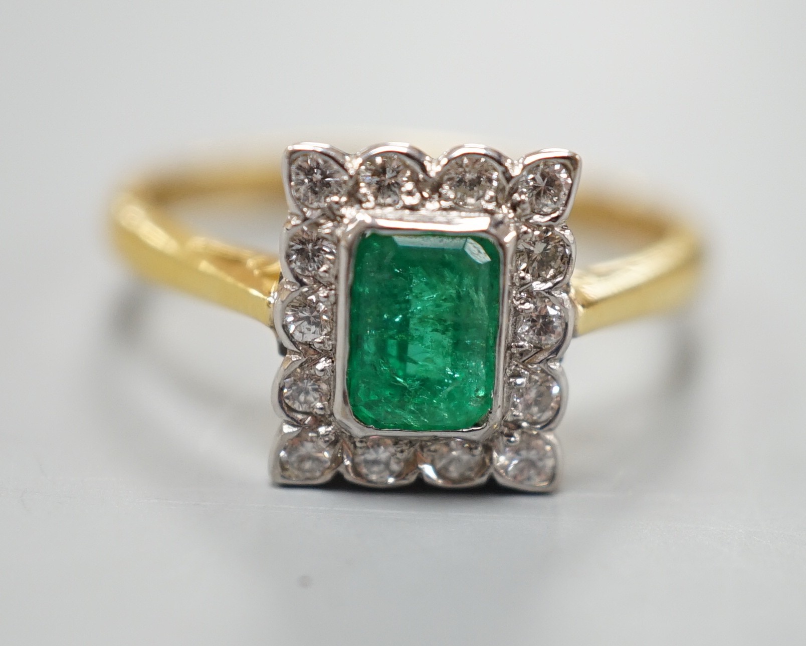 A modern 18ct gold, emerald and diamond set rectangular cluster ring, size N, gross weight 3.4 grams